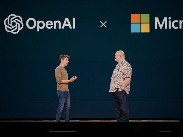 Sam Altman faces Kevin Scott on a stage, with their company logos behind them. Sam Altman faces Kevin Scott on a stage, with their company logos behind them.