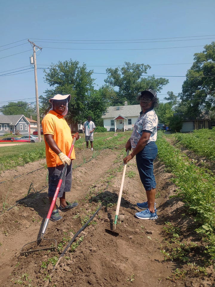 A group of four people standing around a wheelbarrow in a field. A young girl kneeling down in a field. A couple of young people preparing soil in a field. An image of Guy and his wife standing in the field with tools in hand. 
