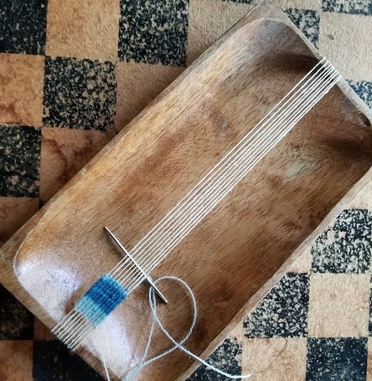 This may contain: a piece of wood sitting on top of a checkered floor next to a string