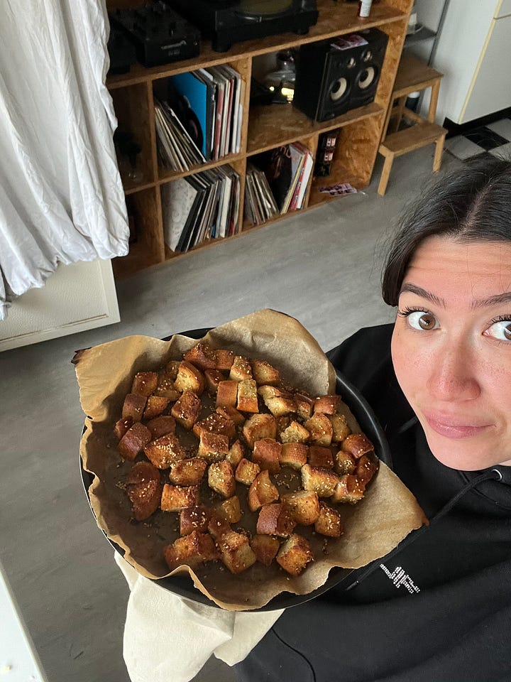 Voorbereiding: "Stukjes brood gemengd met gekruide olijfolie, verspreid op een bakplaat klaar om te bakken."  Tijdens het bakken: "Croutons die goudbruin worden in de oven op een bakplaat."  Eindresultaat: "Goudbruine, knapperige croutons in een schaal, klaar om te serveren."  Met een salade: "Frisse groene salade gegarneerd met zelfgemaakte knapperige croutons."  Close-up: "Close-up van perfect goudbruine en kruidige croutons met een knapperige textuur."