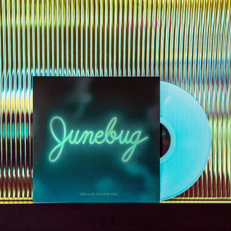 A photo of a vinyl. It's teal tinted and has writing Junebug on it