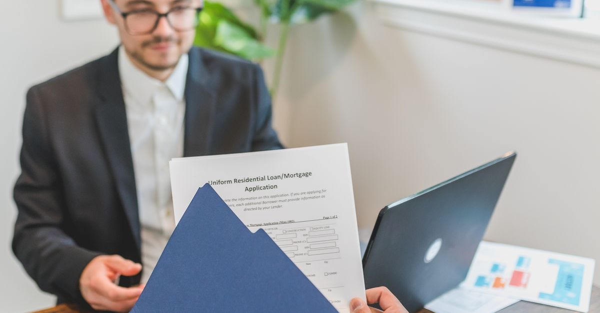Photo: RDNE Stock project / Pexels Mortgage broker and client discussing loan application with documents on table.