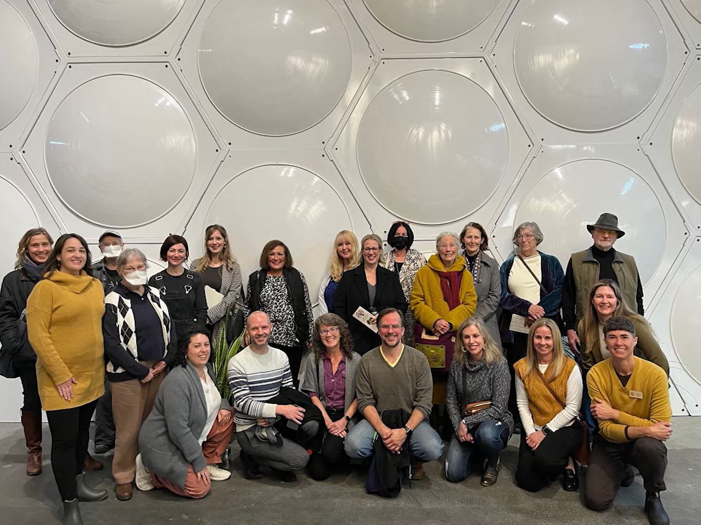 The Recompose team lined up in front of a bank of white metal pods The Recompose team lined up in front of a bank of white metal pods