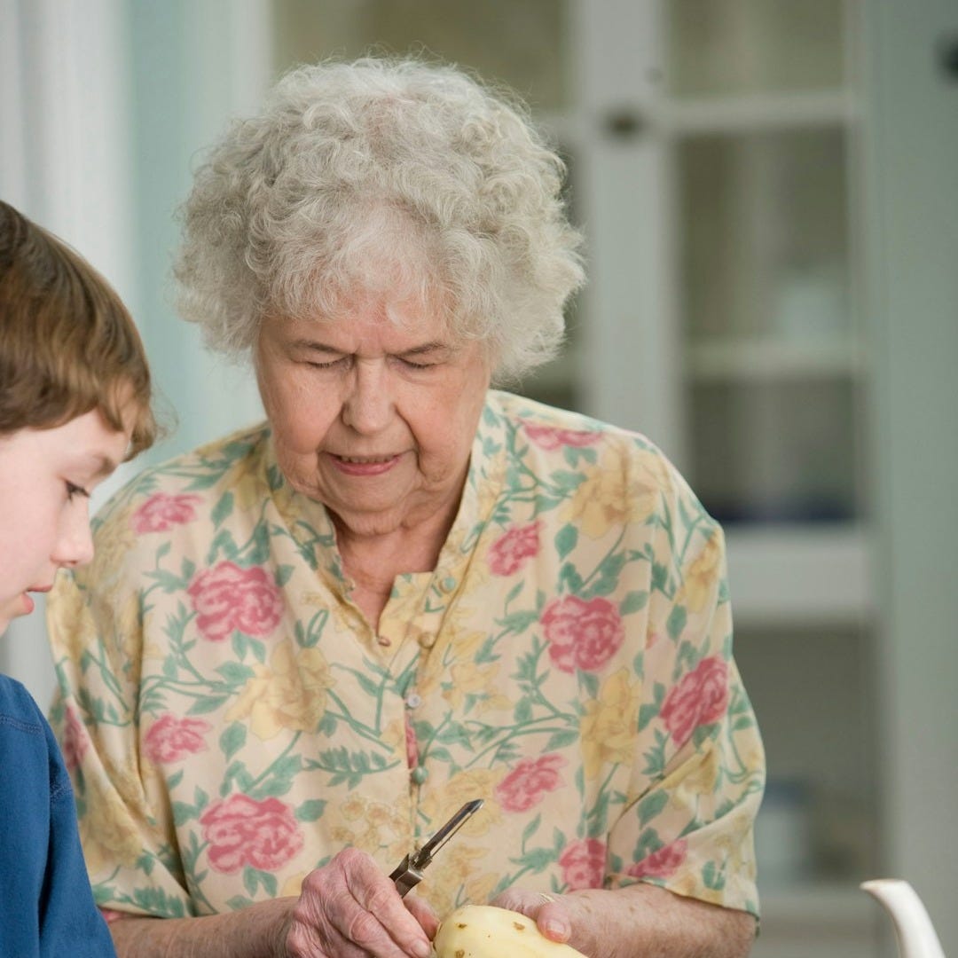 woman in yellow and white floral button up shirt holding yellow banana