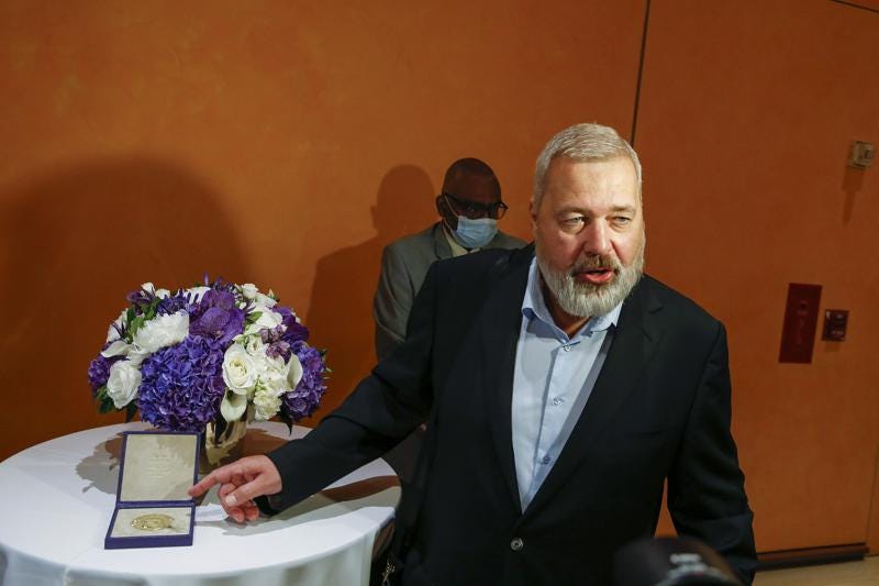 Nobel Peace Prize winner Dmitry Muratov, editor-in-chief of the influential Russian newspaper Novaya Gazeta, poses for a picture next to his 23-karat gold medal before it is auctioned at the Times Center, Monday, June 20, 2022, in New York. (AP Photo/Eduardo Munoz Alvarez)