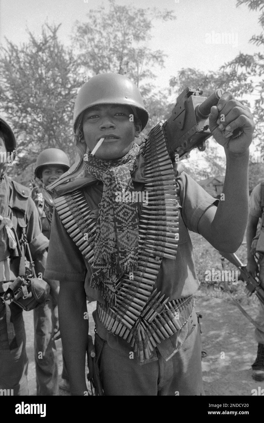 Draped in a long belt of bullets, a Cambodian soldier carries his machine  gun on his shoulder as he marches with his unit near Prek Kdam, some 18  miles north of Phnom