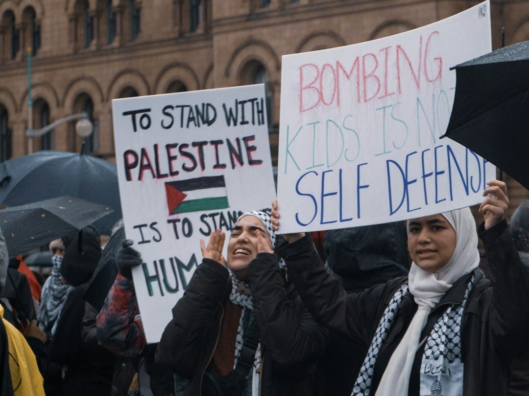 a group of people holding signs in front of a building a group of people holding signs in front of a building