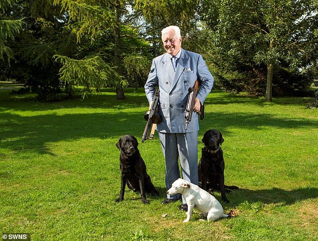Aristocrat Sir Benjamin Slade out on his estate with three of his dogs, carrying a gun under each arm