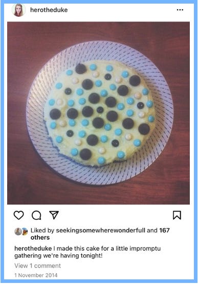 Hero posts an image of the top of a cake with white icing; the blue, white, and brown chocolate pieces form triangles pointing in a star-shape. Caption reads: I made this cake for a little impromptu gathering we're having tonight!