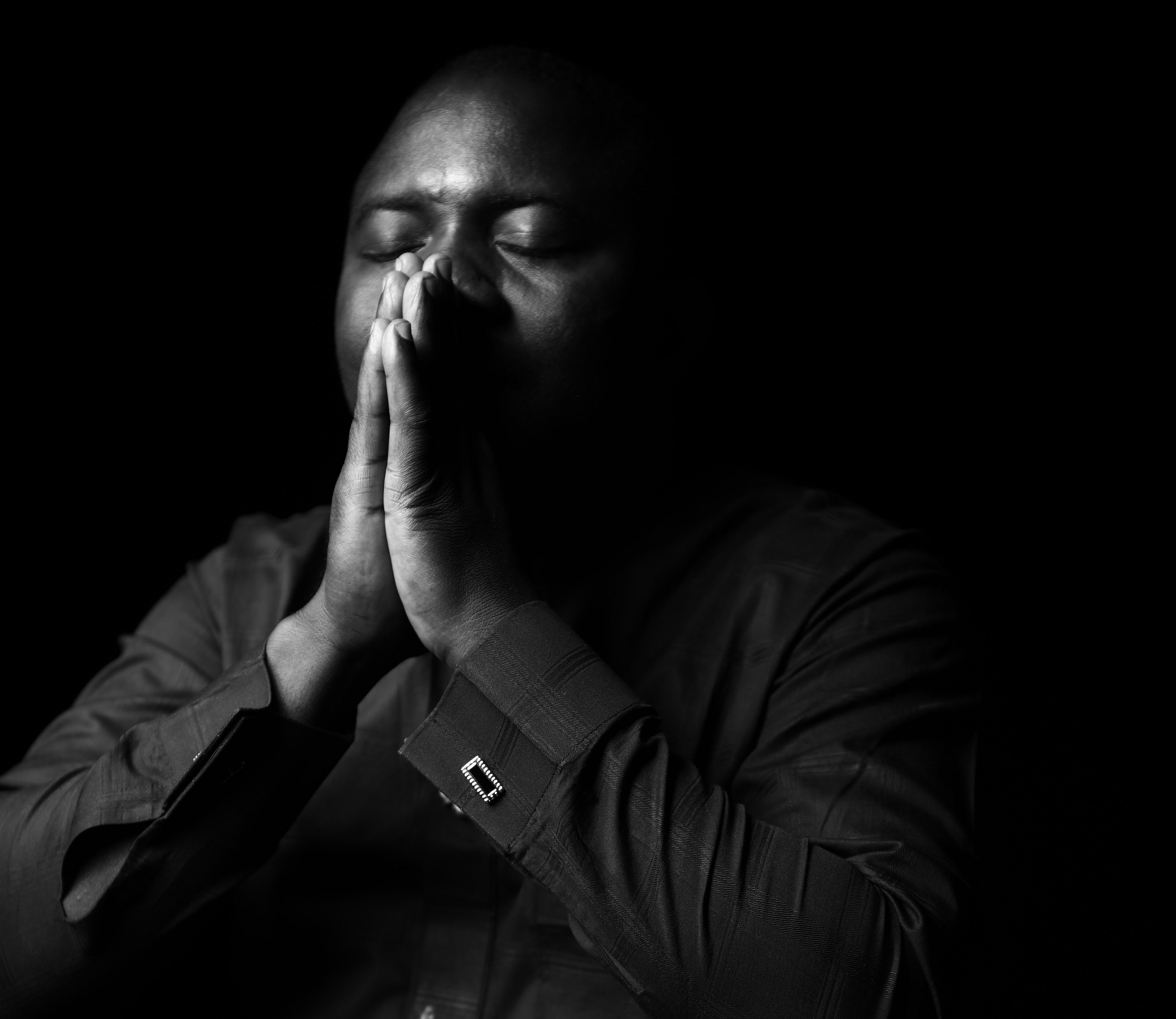 Man with hands clasped over mouth in prayer Man with hands clasped over mouth in prayer