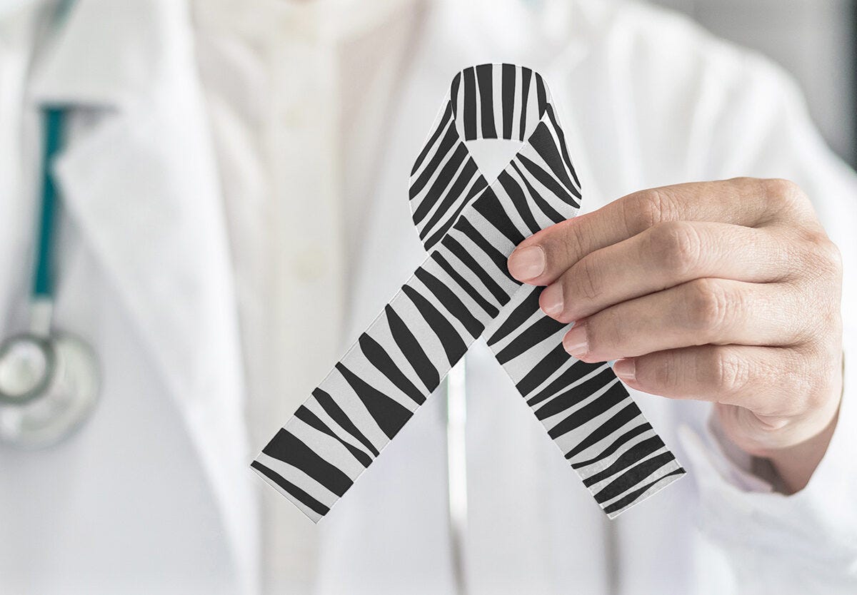 Doctor holding up a zebra ribbon to support Ehlers-Danlos Syndrome (EDS) Awareness Month, symbolizing advocacy for invisible illnesses and hypermobility disorders.