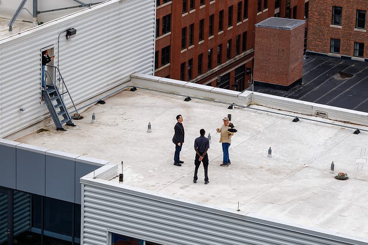 Two rooftop scenes showing Falconer explaining hawk presence to hotel staff during urban bird control.