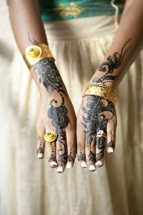 This may contain: a woman's hands with tattoos and rings on them