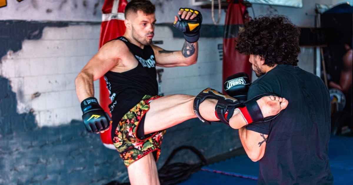 Two men engaged in a dynamic kickboxing training inside a gym Two men engaged in a dynamic kickboxing training inside a gym