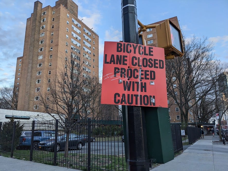 sign reads "bicycle lane closed, proceed with caution"