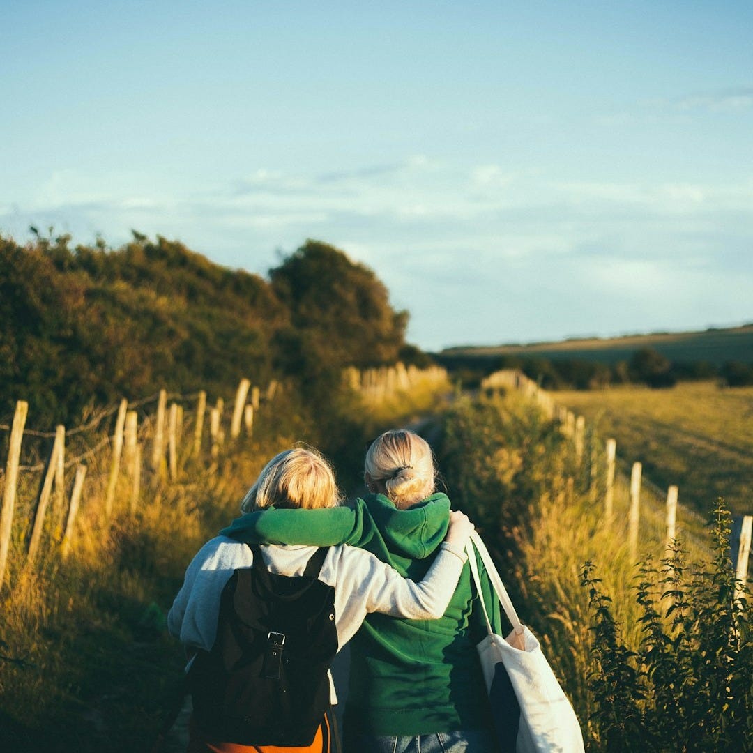 two women walking together outdoor during daytime