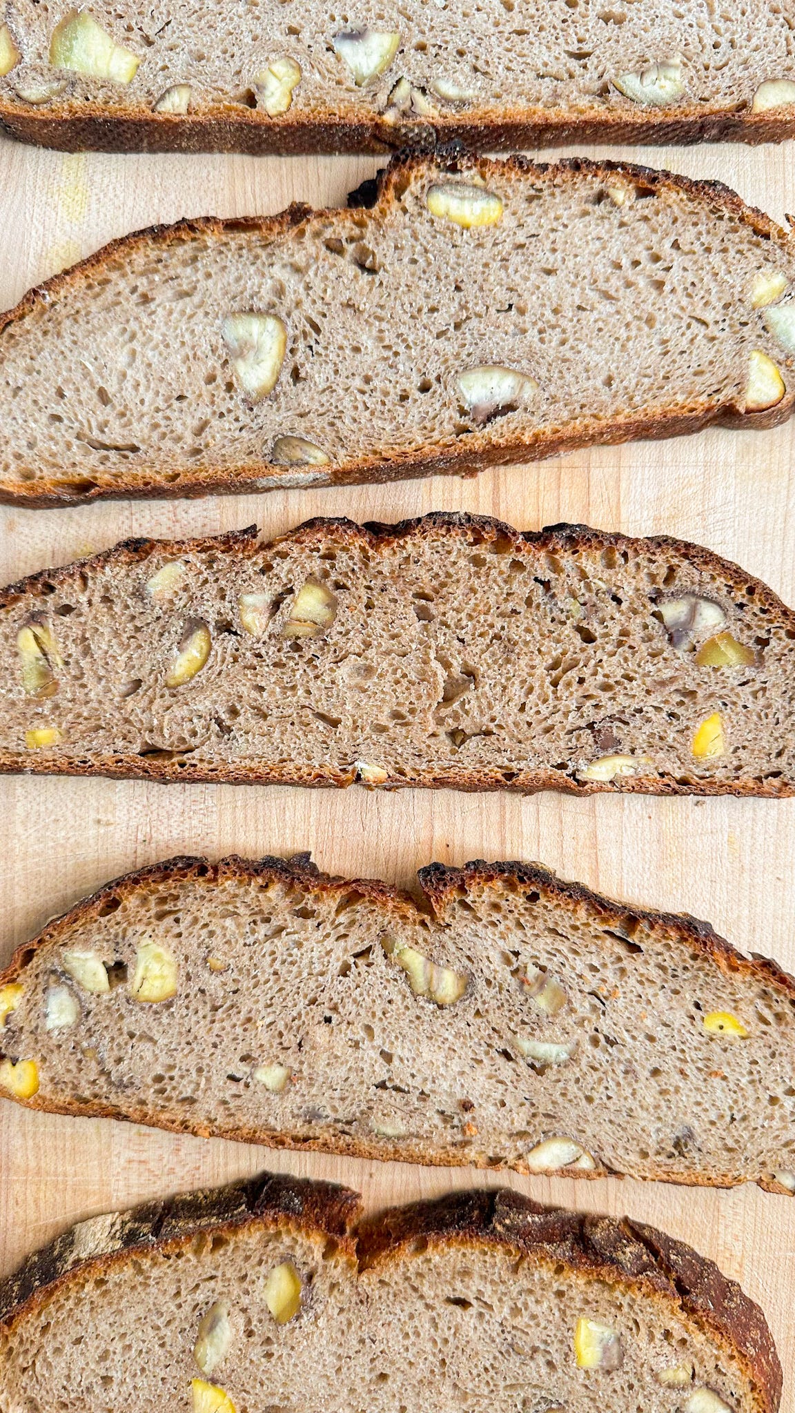 Slices of chestnut bread, with visible chunks of cooked chestnut.