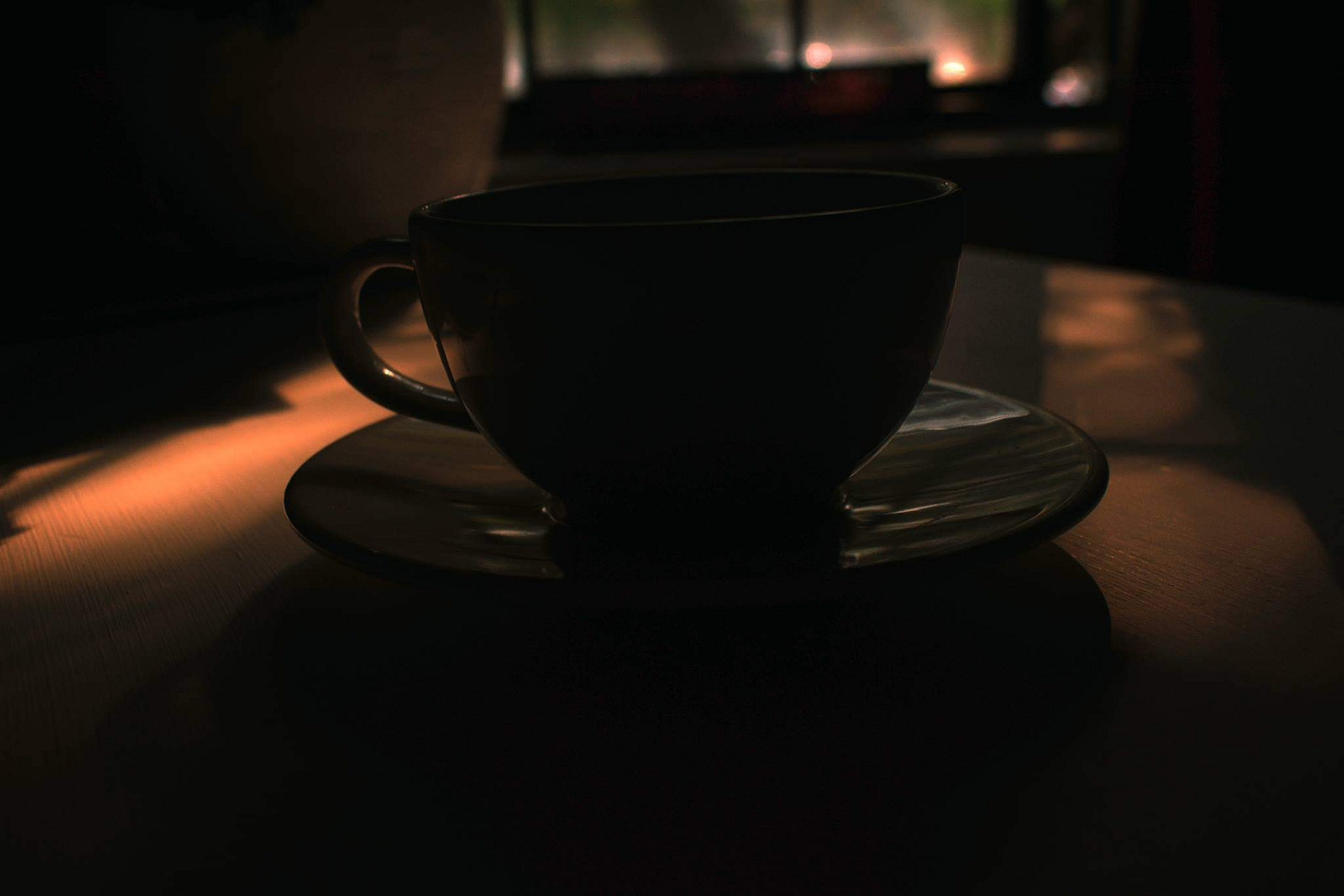 Photograph of a coffee cup in numinous lighting.  Photograph from "Cauldrons Near and Far" entry to "Thought Bubbles" by Jeffrey Puukka
