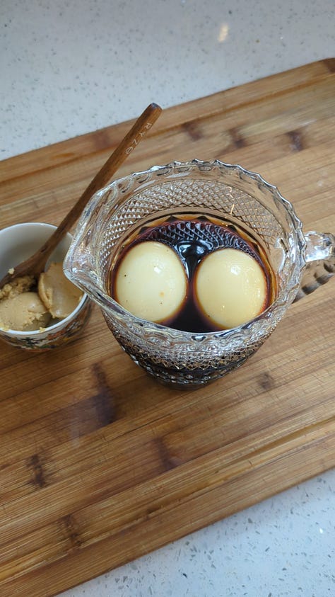 Jammy-centered ramen eggs, marinating in soy mixture to add a delicious flavor.