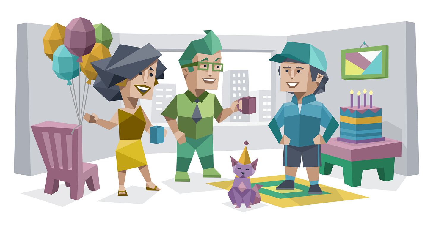 A birthday celebration in an office. Three smiling adults stand together near a table holding a layered birthday cake with lit candles. One person holds a bunch of balloons, another holds a coffee mug, and a small purple cat wearing a party hat sits in the foreground.