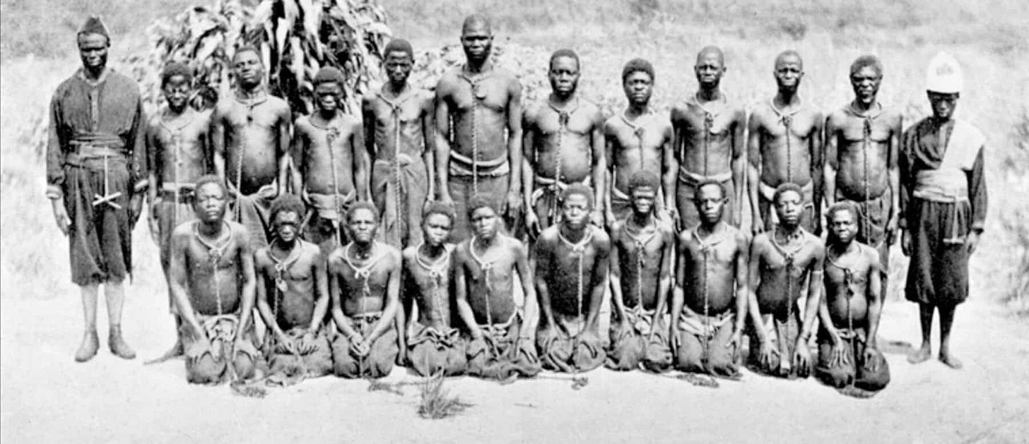 Two rows of prisoners with chains around their necks