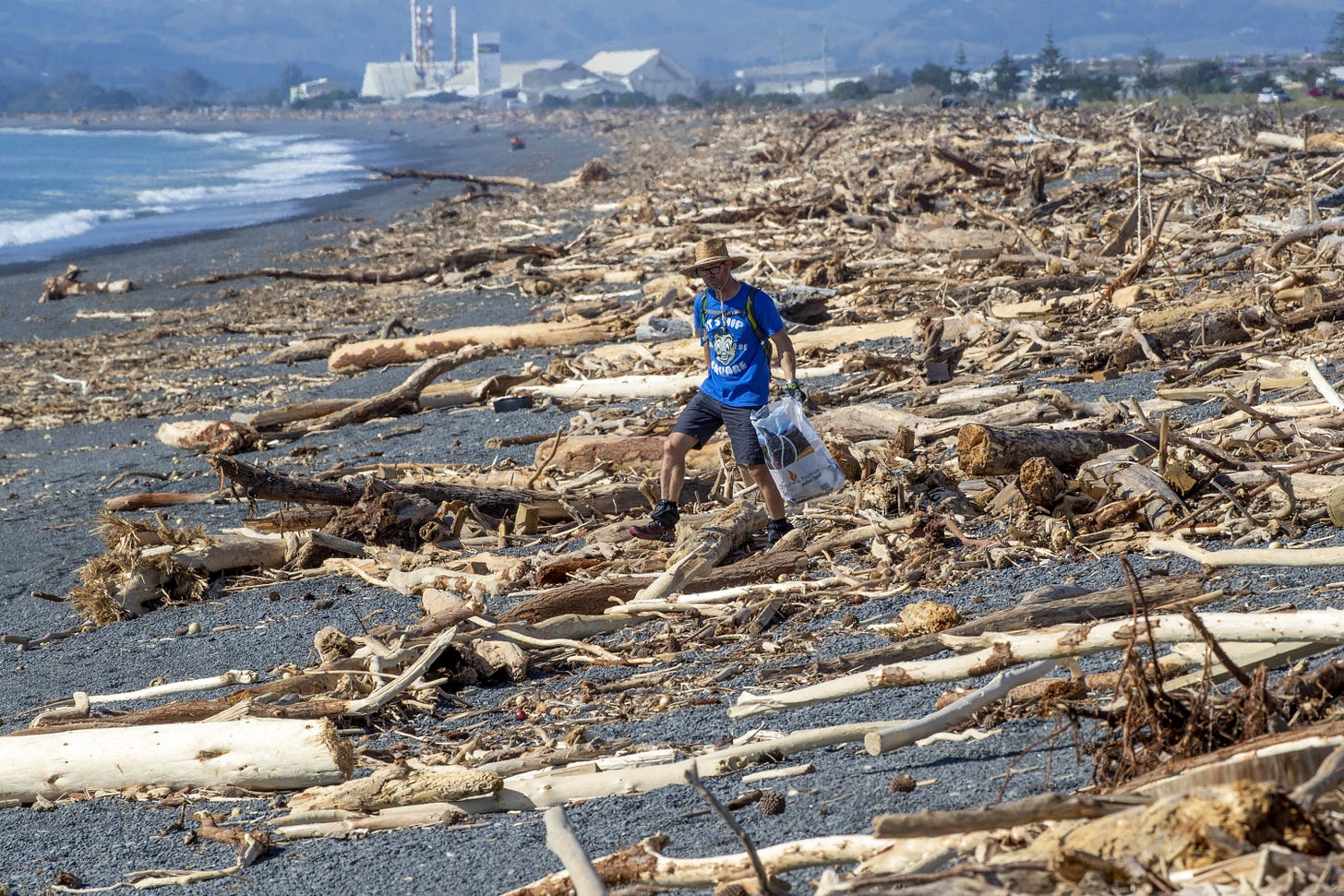 "A resident walks among the debris washed ashore from Cyclone Gabrielle, Napier."