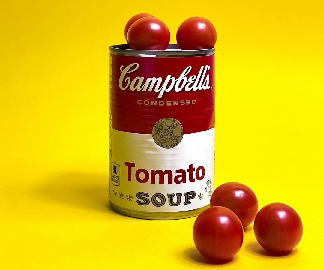 a can of tomato soup on a yellow background