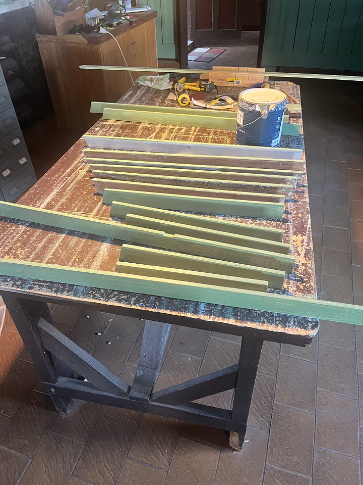 A wall with two interior windows and some trim being prepared