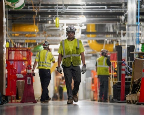Workers in dirty hi-vis jackets in a data centre