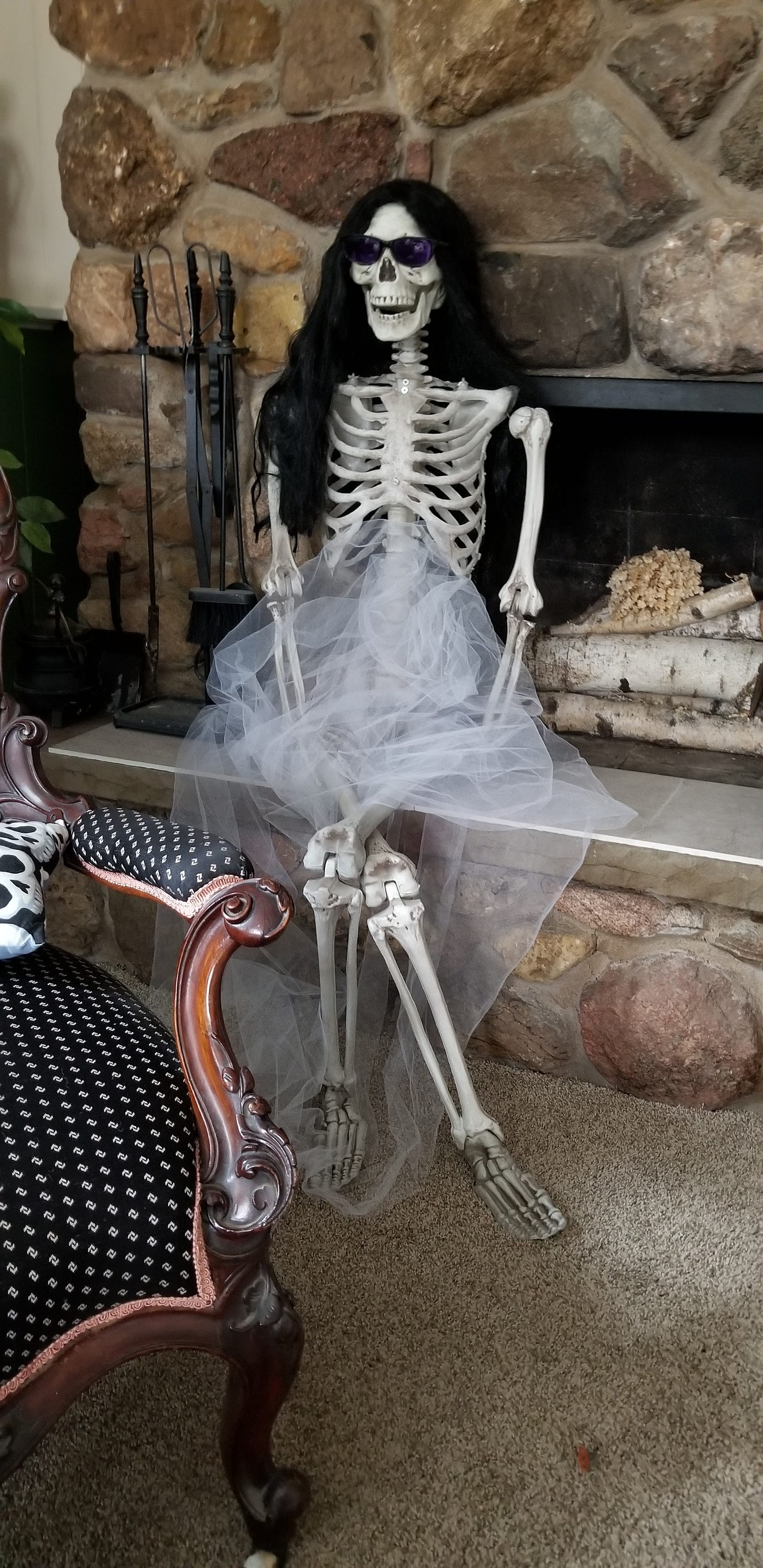A fake skeleton with a wig and sunglasses.
