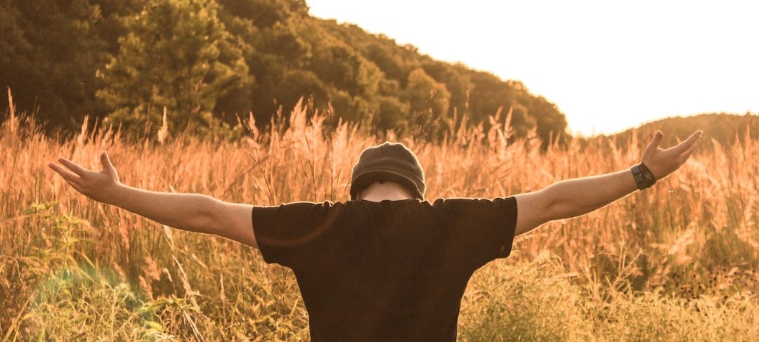 man standing in the middle of field man standing in the middle of field