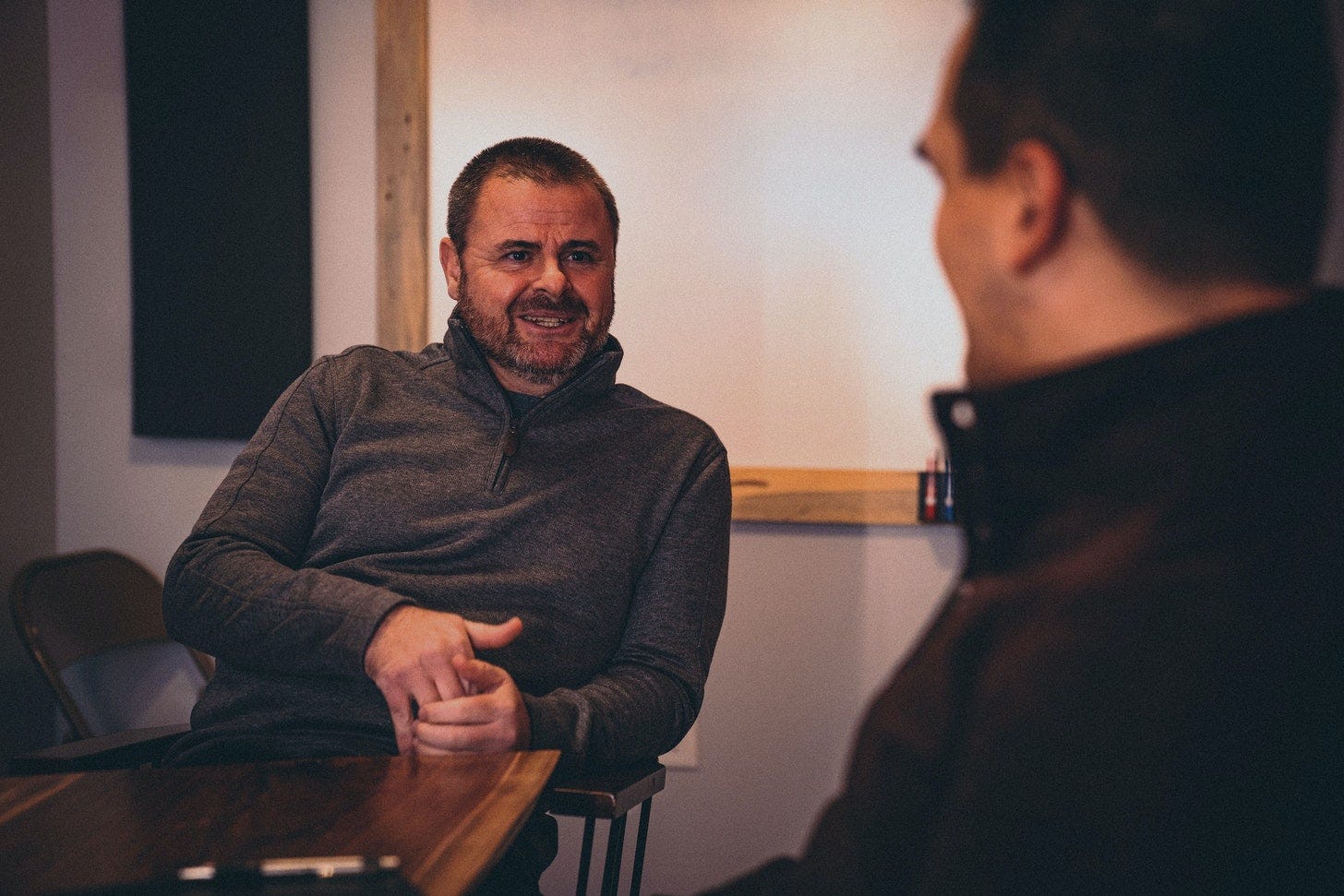Mark and Brian chatting at a table in Big Slate's studios.