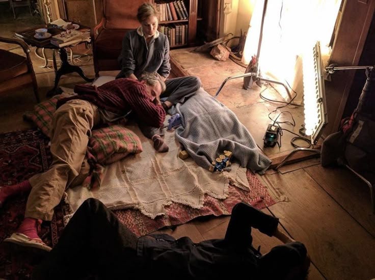 This may contain: two people sitting on a bed in a room This may contain: two people sitting on a bed in a room