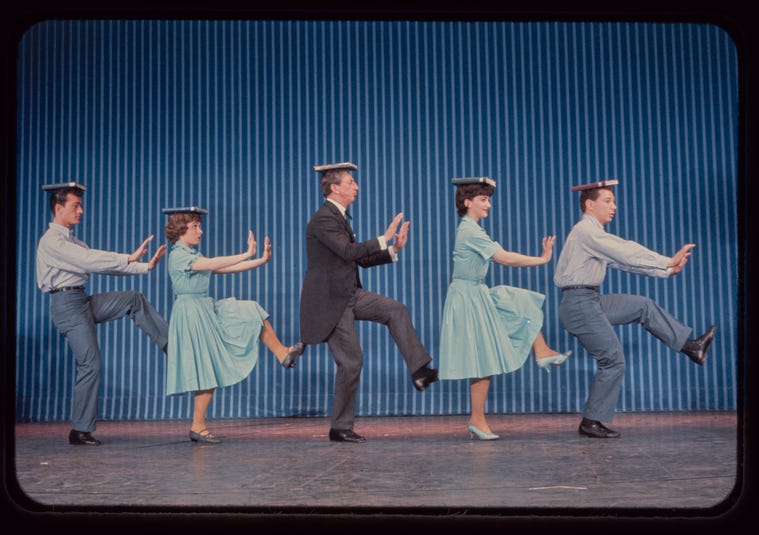 Five Dancers high stepping on a braodway stage with books on their heads (1950s) (try something new) Five Dancers high stepping on a braodway stage with books on their heads (1950s) (try something new)