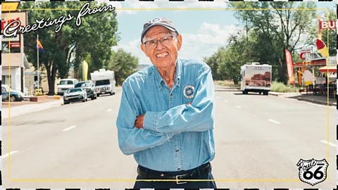 Johnny Kompar/ Serenity Strull/ BBC Angel Delgadillo stands in the middle of wide street on Route 66 in a postcard-style image reading "Greetings from Route 66" (Credit: Johnny Kompar/ Serenity Strull/ BBC) Johnny Kompar/ Serenity Strull/ BBC Angel Delgadillo stands in the middle of wide street on Route 66 in a postcard-style image reading "Greetings from Route 66" (Credit: Johnny Kompar/ Serenity Strull/ BBC)