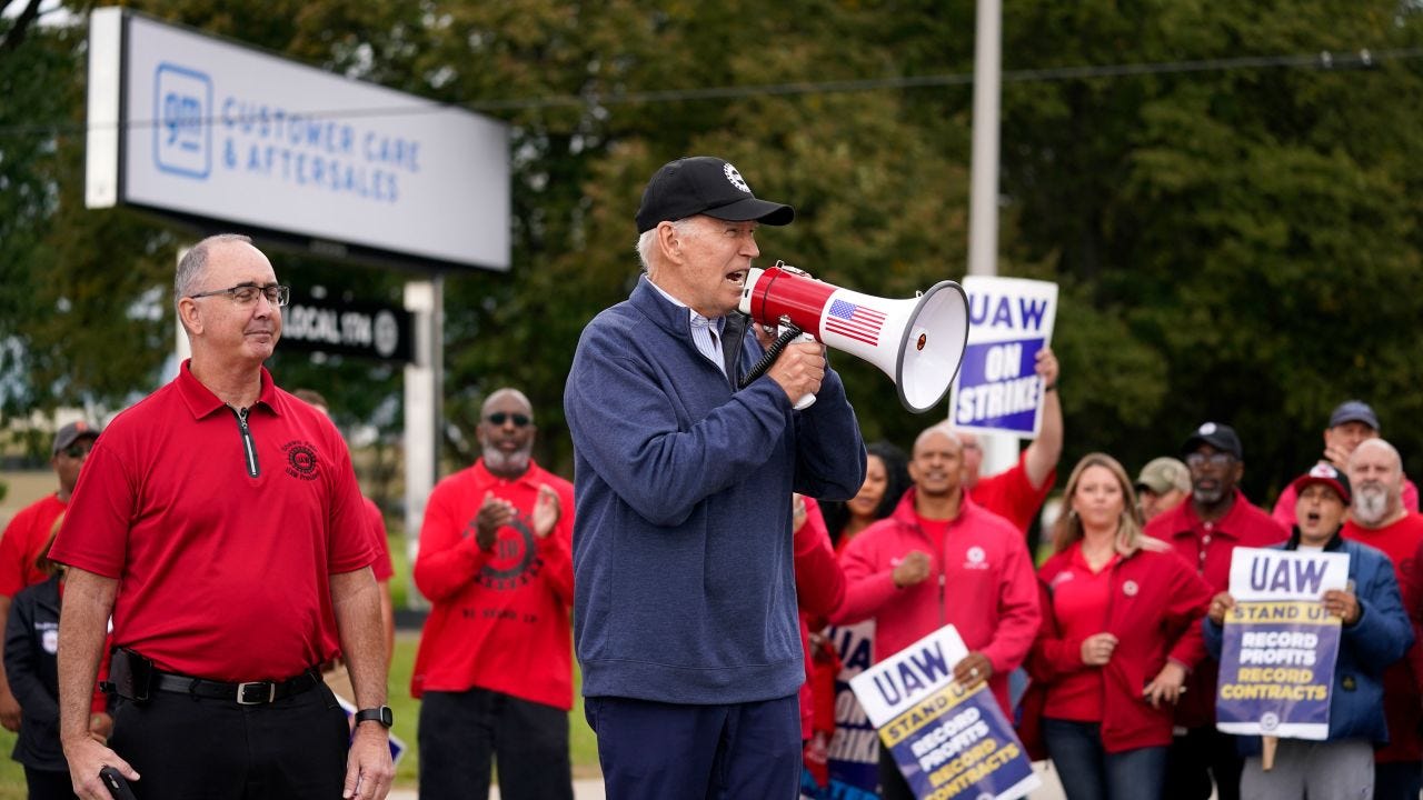 President Joe Biden joins striking United Auto Workers on the picket line, in Van Buren Township, Mich. United Auto Workers President Shawn Fain stands at left. 