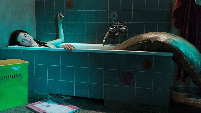 This may contain: a woman laying down in a bathtub with her arm extended and head resting on the edge