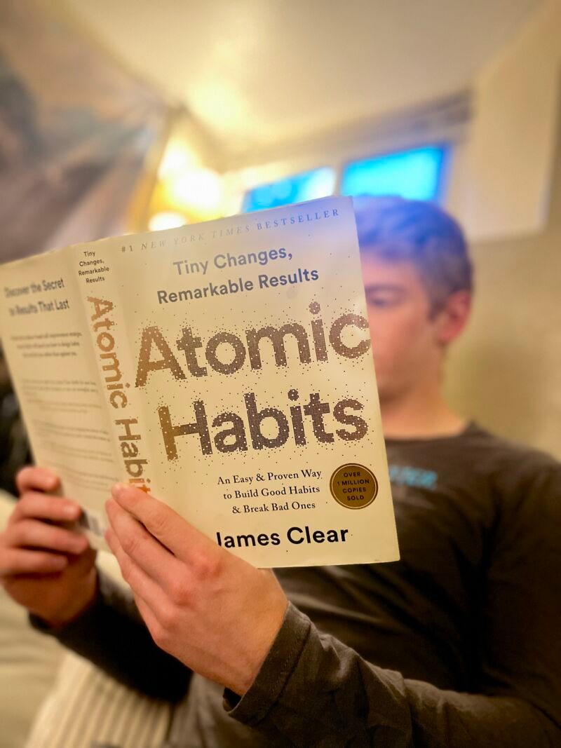 a picture of a person holding a book and posing for the camera