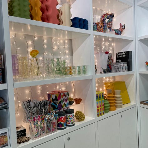 A table with a glass of wine, an art workshop, and the gift shop