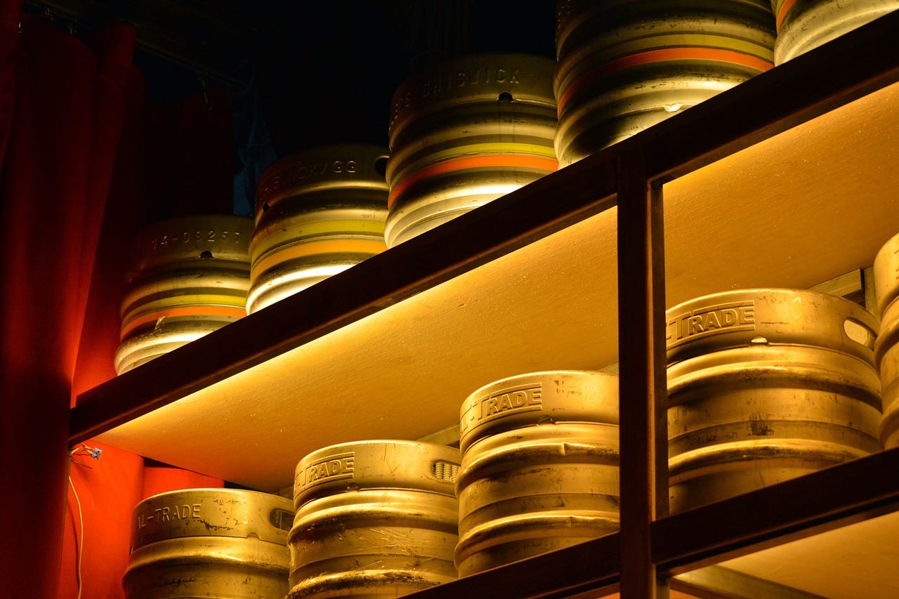 Kegs of beer on shelves, lit from below