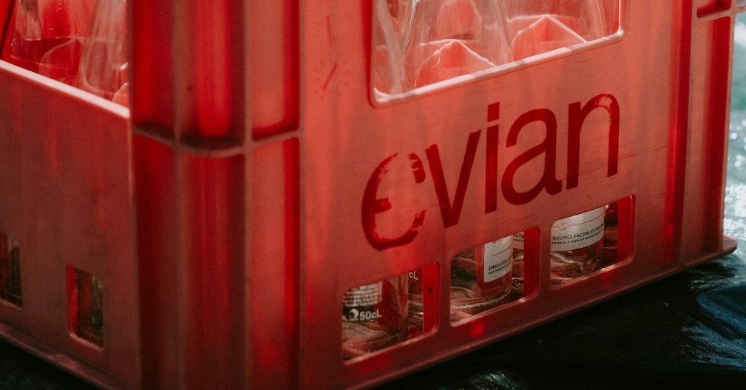 a red crate filled with empty bottles on top of a table a red crate filled with empty bottles on top of a table