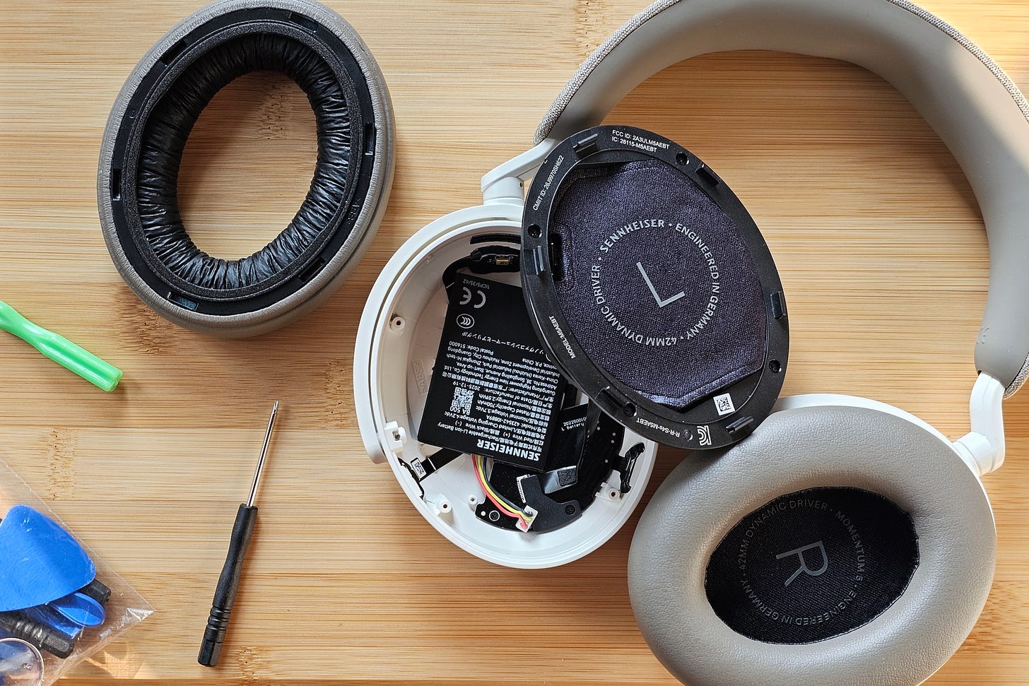 Sennheiser Momentum 5 Wireless with left earcup disassembled to show replaceable battery. Sennheiser Momentum 5 Wireless with left earcup disassembled to show replaceable battery.