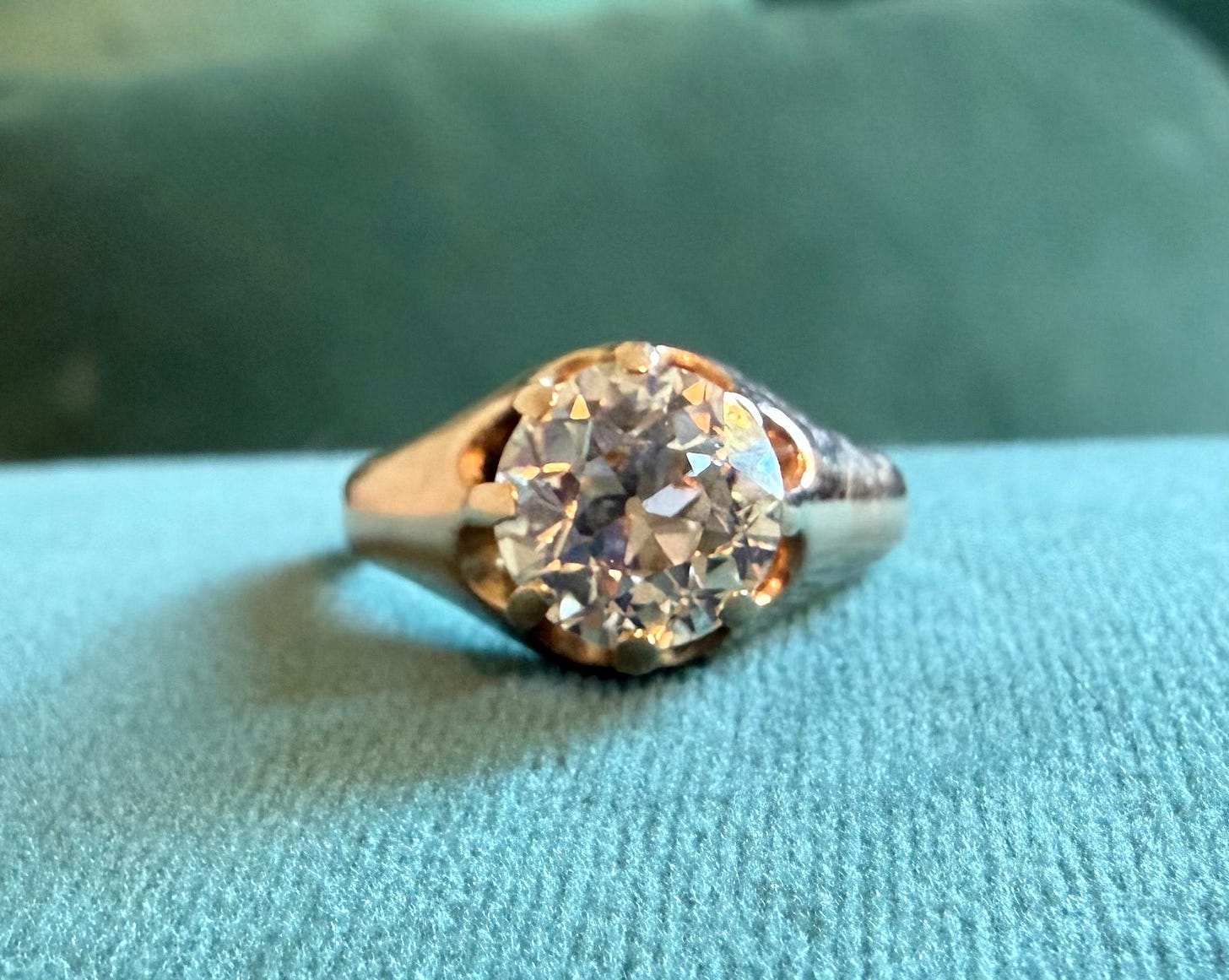 textured large diamond ring gold band on blue cloth textured large diamond ring gold band on blue cloth