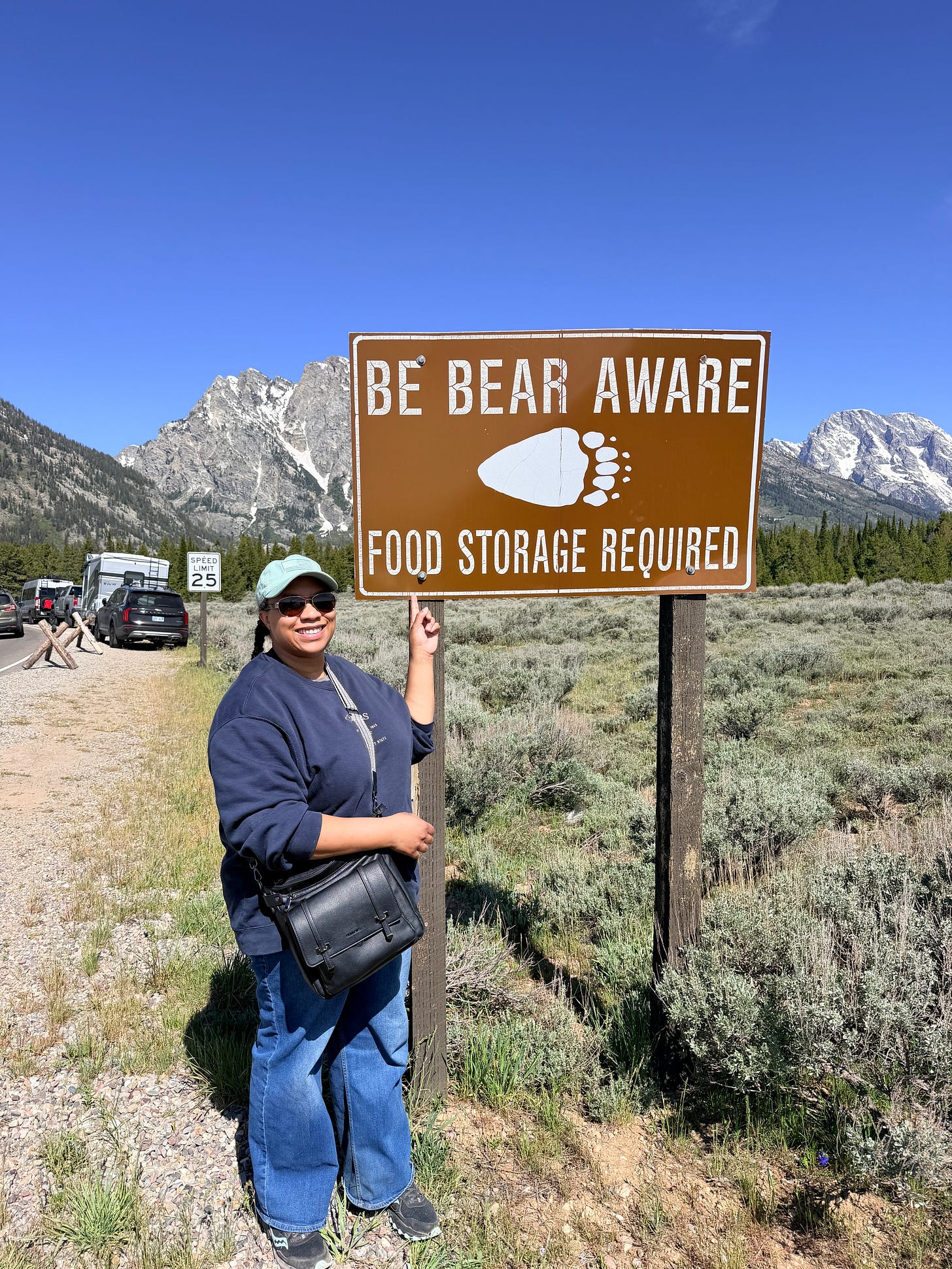 Ashley standing pointing to a "Be Bear Aware" sign Ashley standing pointing to a "Be Bear Aware" sign