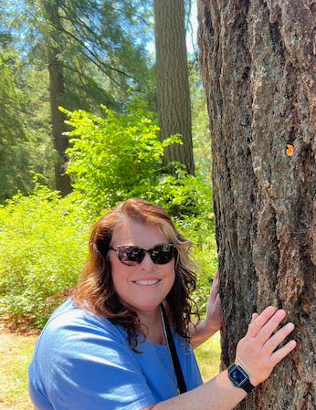 Author, Melinda Pajak, hugging a redwood tree.