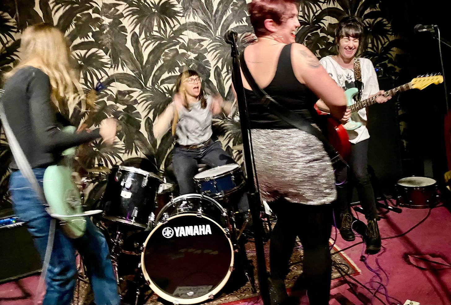 Four women in a rock band in a blurry photograph