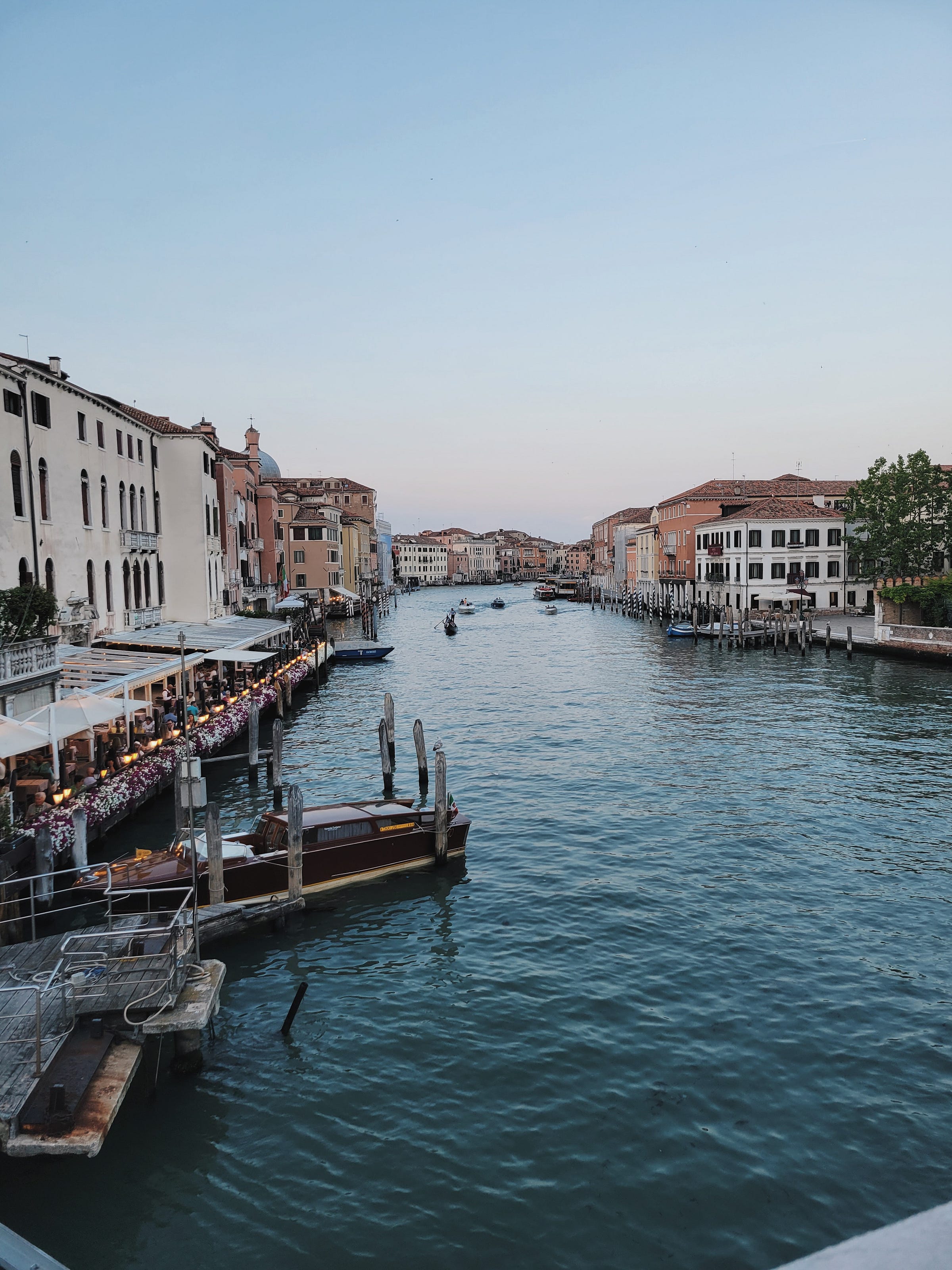 The Grand Canal in Venice at dusk, with gondolas crossing the blue-green water The Grand Canal in Venice at dusk, with gondolas crossing the blue-green water