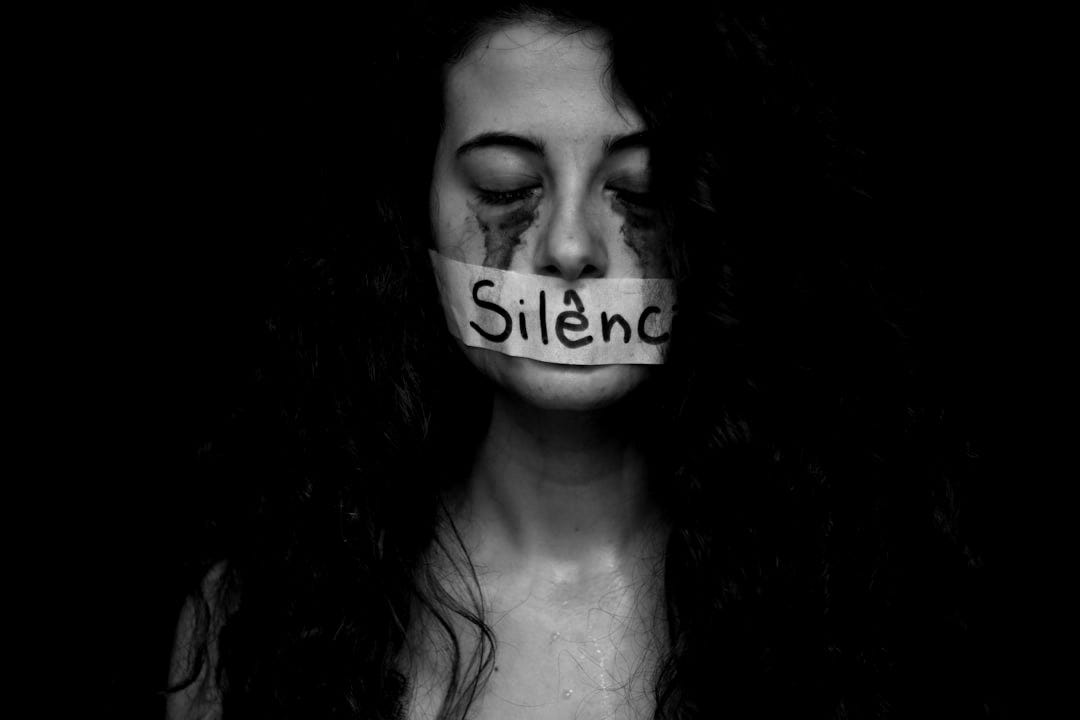 Silence symbolized by tape on a woman's mouth. Silence symbolized by tape on a woman's mouth.