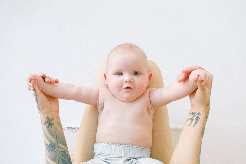 A chubby little baby holding its parent’s hands A chubby little baby holding its parent’s hands