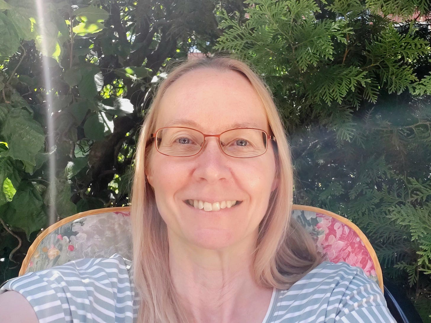 Claudia Kollschen on a garden chair in the green (June 2025)